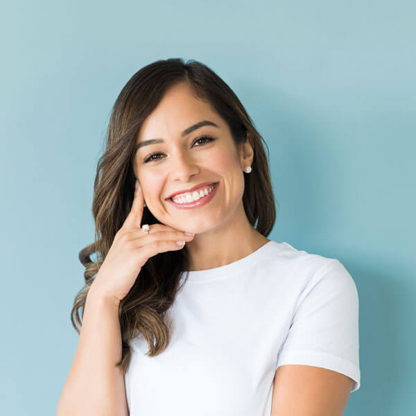 woman smiling and standing against blue wall