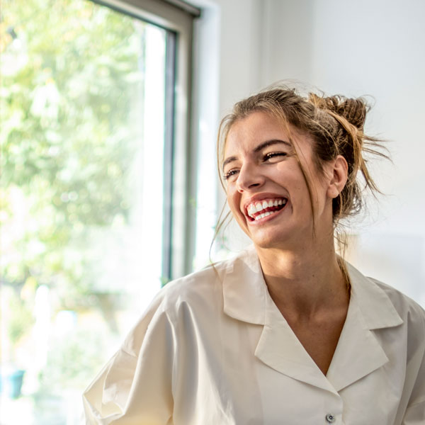 woman laughing while looking to the side