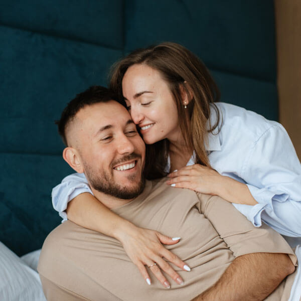 man and woman smiling while hugging