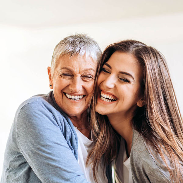 mature woman laughing with younger woman