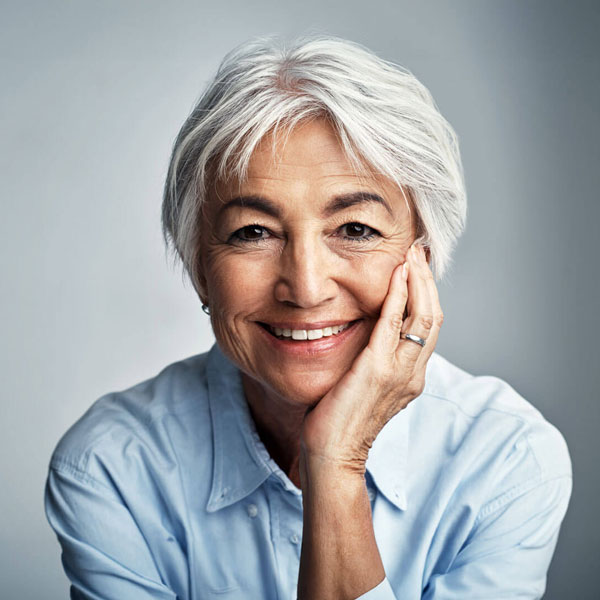 mature woman smiling with hand on face