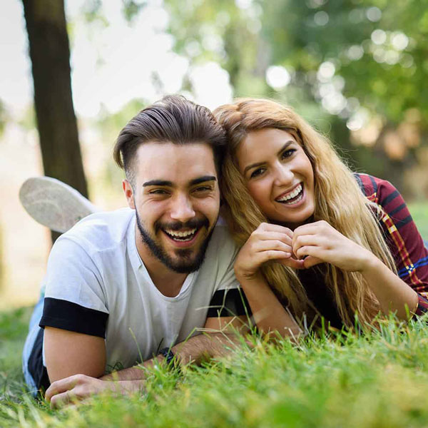 man and woman smiling together outdoors