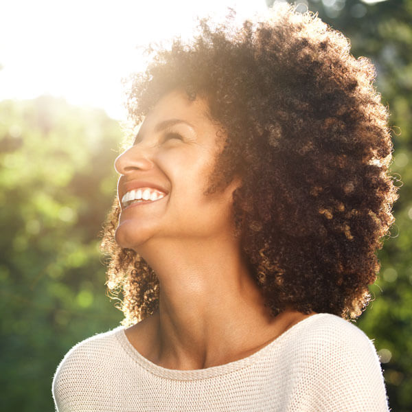 woman smiling outdoors in the sun