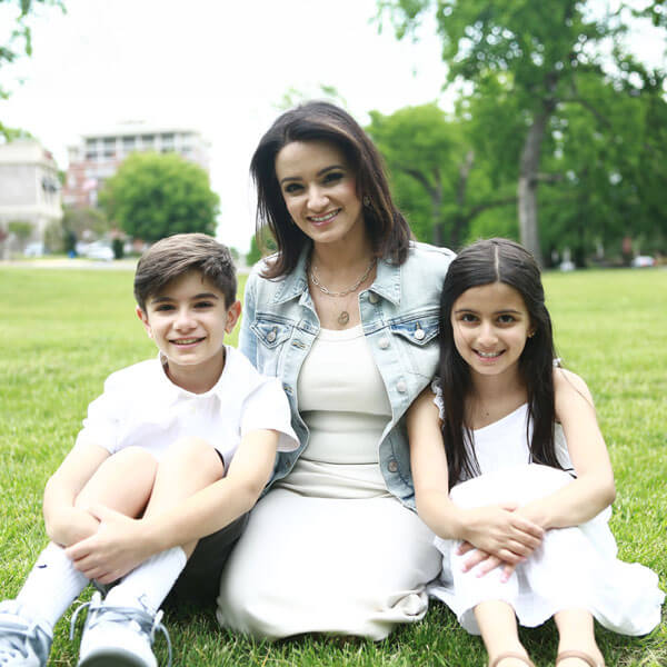 mother smiling with son and daughter in the park